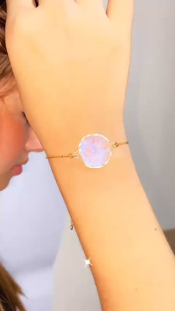 Iridescent round bracelet worn at the wrist